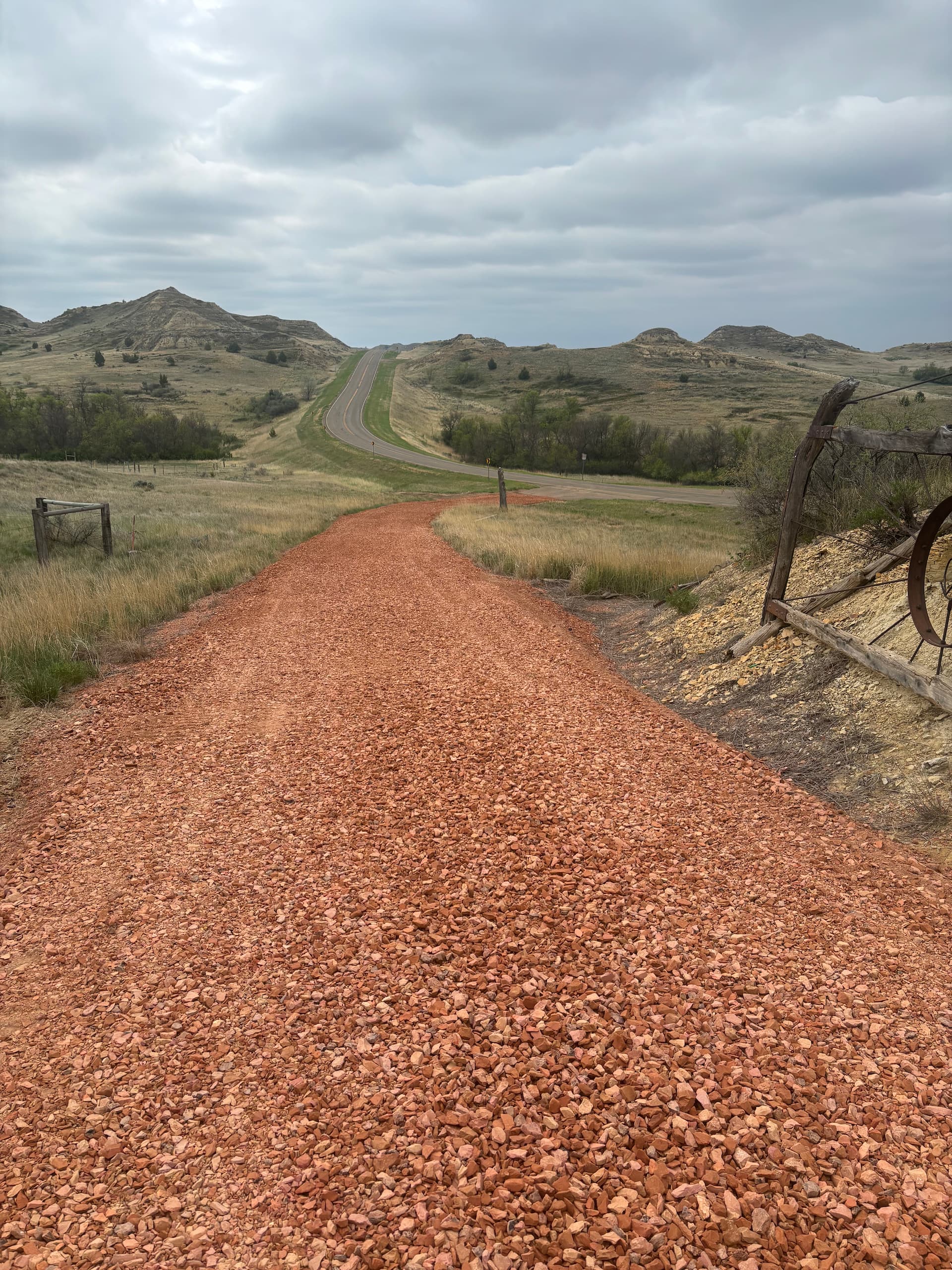 Road cutting through hills and a scoria road in the foreground