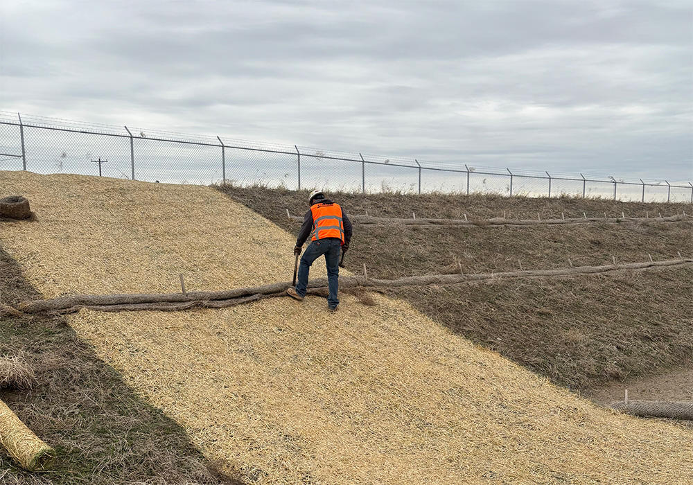 Person in a safety vest standing on sloped land